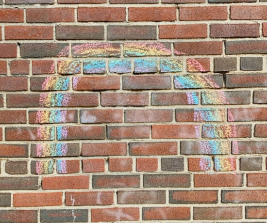 chalk rainbow drawn on a brick wall