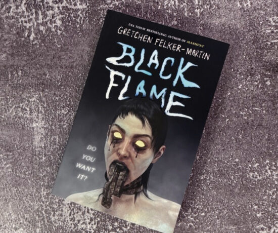 A paperback copy of the book Black Flame by Gretchen Felker-Martin sitting on a distressed cement background.